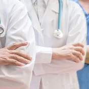 Ein Arzt, eine Ärztin und eine Krankenschwester stehen nebeneinander. Die Experten von AOK-Clarimedis decken viele Fachgebiete ab.