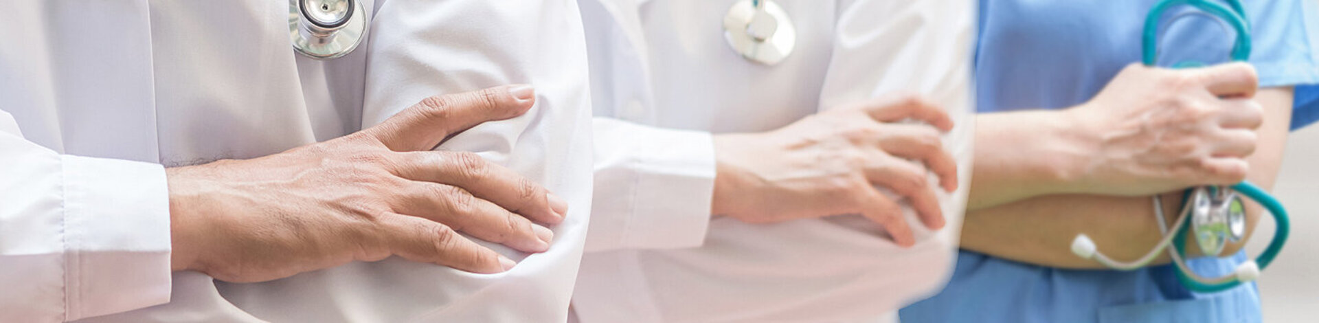 Ein Arzt, eine Ärztin und eine Krankenschwester stehen nebeneinander. Die Experten von AOK-Clarimedis decken viele Fachgebiete ab.