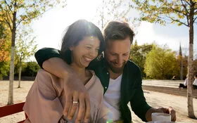 Frau und Mann sitzen auf einer Bank und genießen dank pflanzlicher Stimmungsaufheller ihre gemeinsame Zeit.