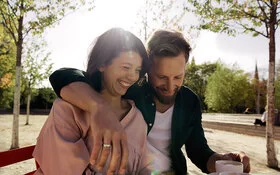Frau und Mann sitzen auf einer Bank und genießen dank pflanzlicher Stimmungsaufheller ihre gemeinsame Zeit.