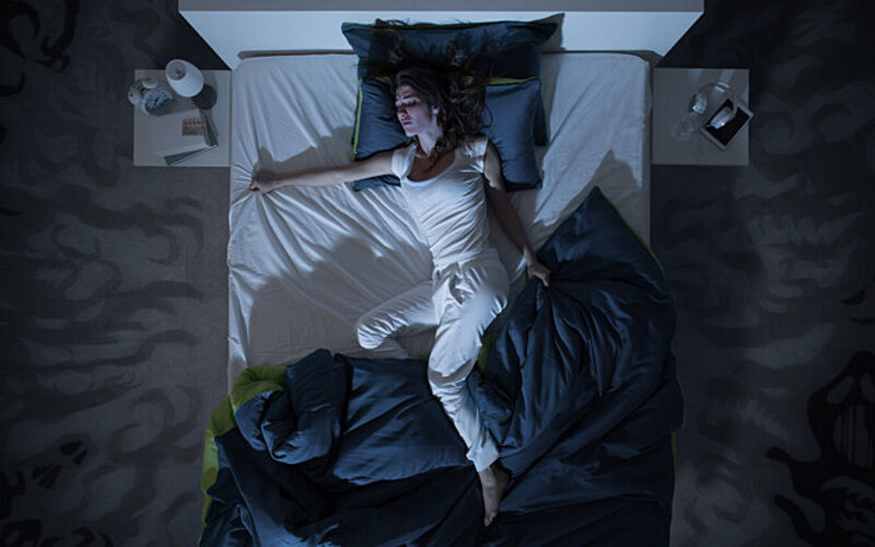 Eine Frau erlebt intensive Träume während des REM-Schlafs.