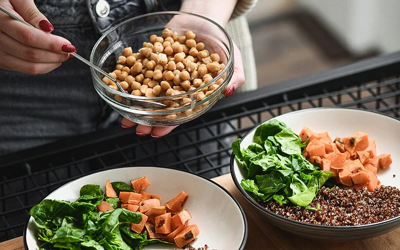 Drei Schalen mit Linsen sowie Salat, Kürbis und Keimen.