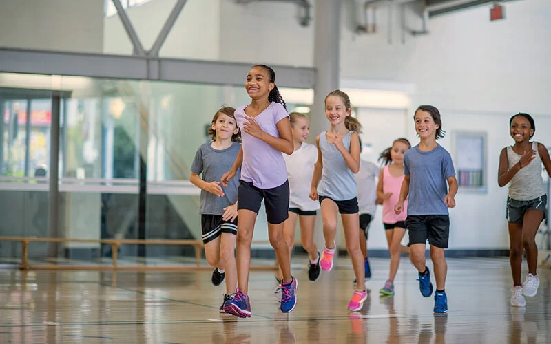 Mädchen und Jungen beim Schulsport in der Sporthalle.