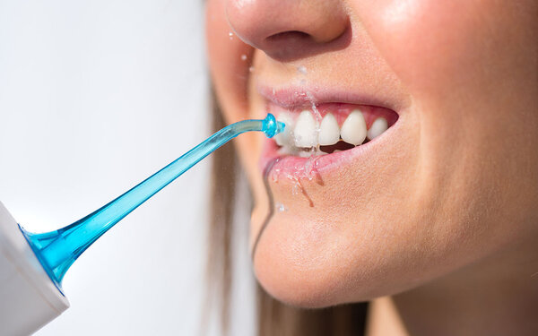 Eine Frau benutzt eine Munddusche.