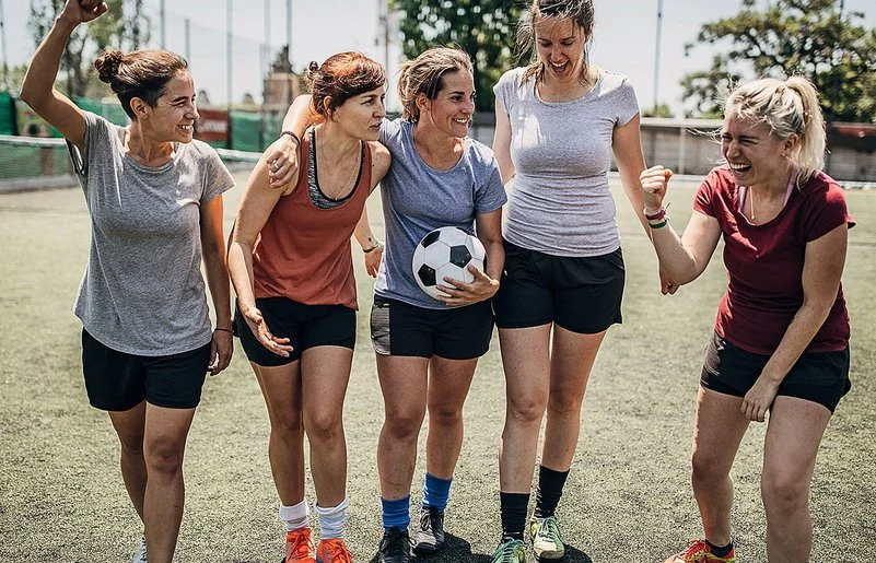 Ein Frauen-Team motiviert sich untereinander beim Fußballspiel.