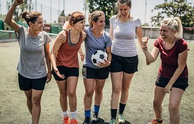 Ein Frauen-Team motiviert sich untereinander beim Fußballspiel.