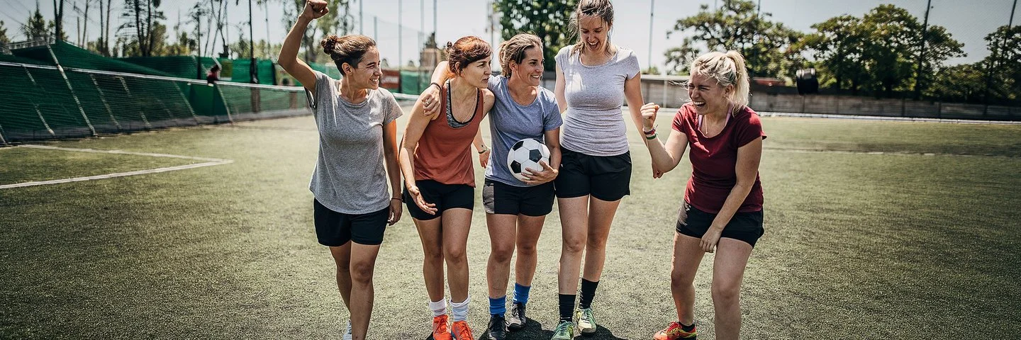 Ein Frauen-Team motiviert sich untereinander beim Fußballspiel.