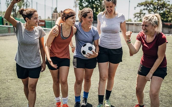 Ein Frauen-Team motiviert sich untereinander beim Fußballspiel.