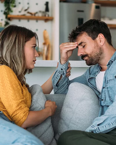 Über Gefühle reden: Ein Paar spricht über die psychische Gesundheit des Mannes im Wohnzimmer.