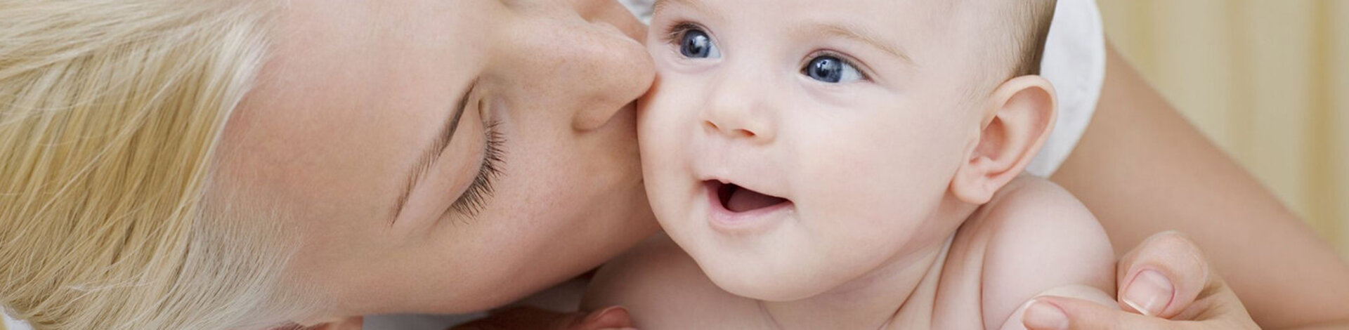 Mama knutscht liebevoll ihr Baby. Baby ist glücklich.