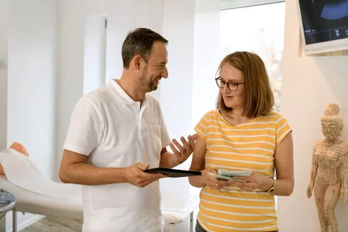 Eine Patientin spricht mit einem Arzt. Arzneimittel kann er künftig mit einem E-Rezept verschreiben.