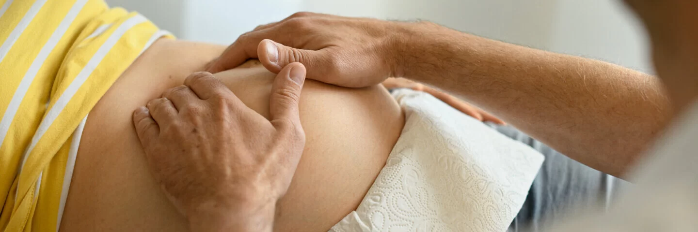 Ein Arzt tastet den Bauch einer Schwangeren ab. Bei Risikoschwangerschaften sind regelmäßige Untersuchungen besonders wichtig. 