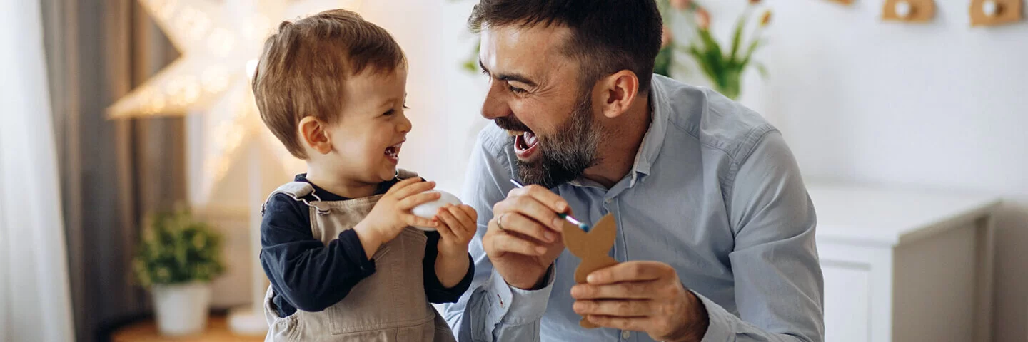 Papa und Kleinkind kommunizieren in Babysprache.