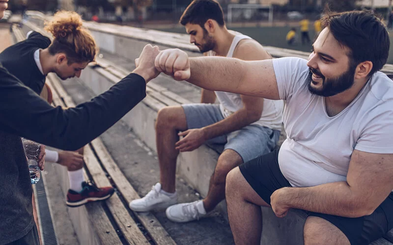 Mehrere Freunde treiben Sport zusammen und schlagen ein.