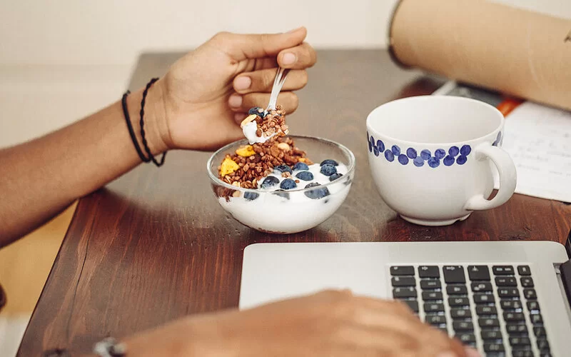 Ein frischer Joghurt mit Obst steht auf dem Tisch – er ist gut für die Darmflora.