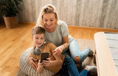 Mutter mit Kind am Boden mit Handy