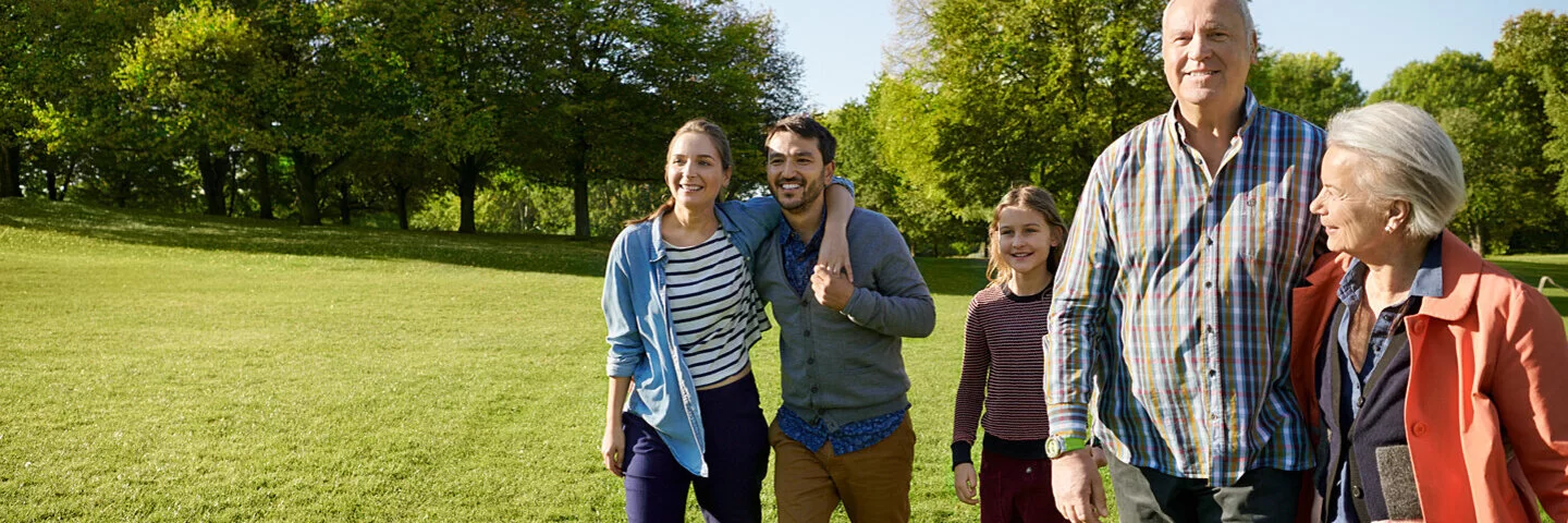 Eine fünfköpfige Familie spaziert gemeinsam über eine Wiese. Als AOK-Versicherte haben sie ein Mitbestimmungsrecht.