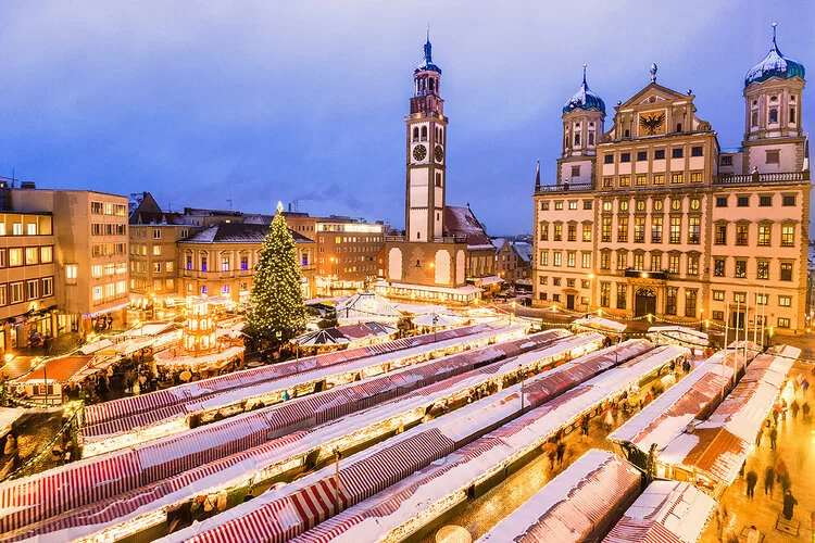 Luftaufnahme auf dem Augsburger Christkindlsmarkt mit Rathaus in der Abenddämmerung.