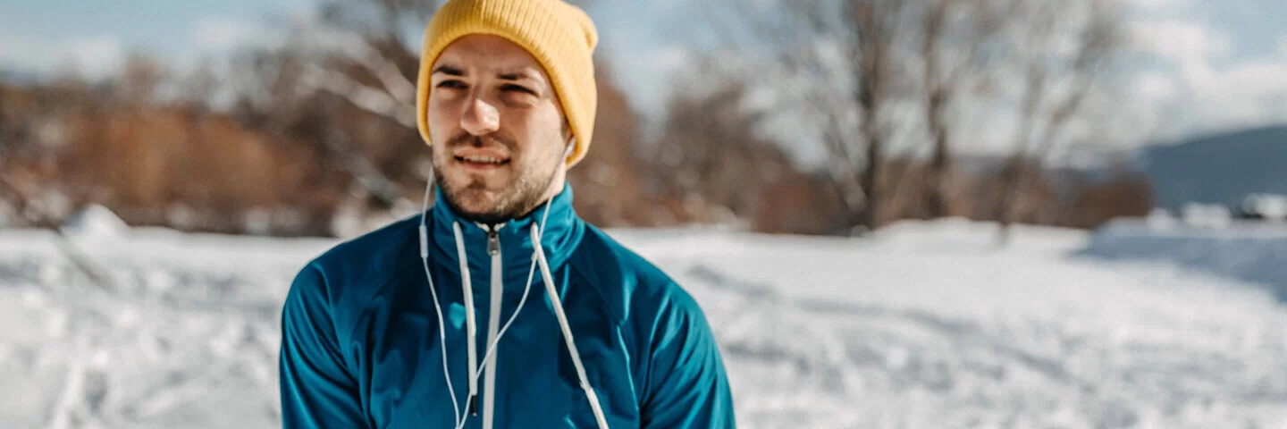 Ein Mann dehnt sich vor dem Joggen im Winter.