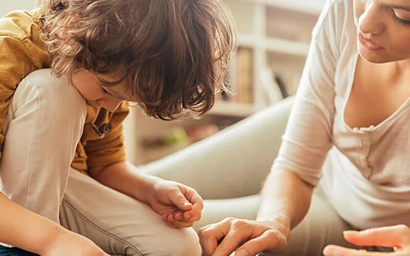 Mutter und Sohn spielen zusammen auf dem Boden.