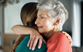 Zwei Frauen umarmen sich, um Empathie auszudrücken.