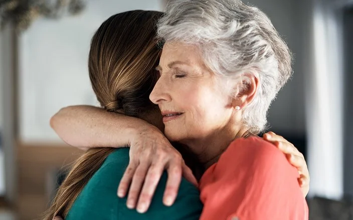 Zwei Frauen umarmen sich, um Empathie auszudrücken.
