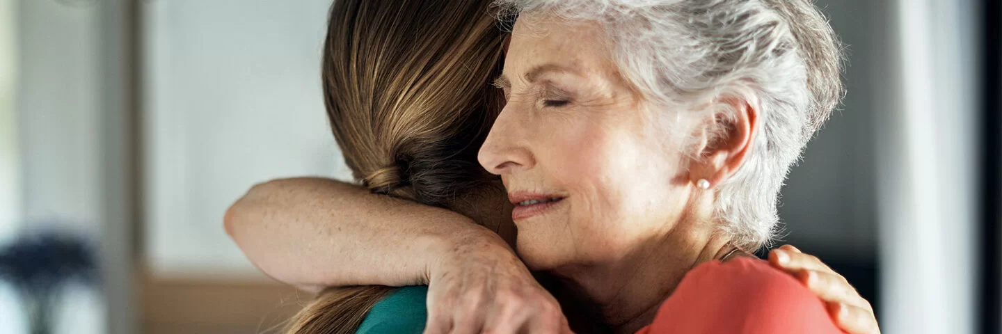 Zwei Frauen umarmen sich, um Empathie auszudrücken.