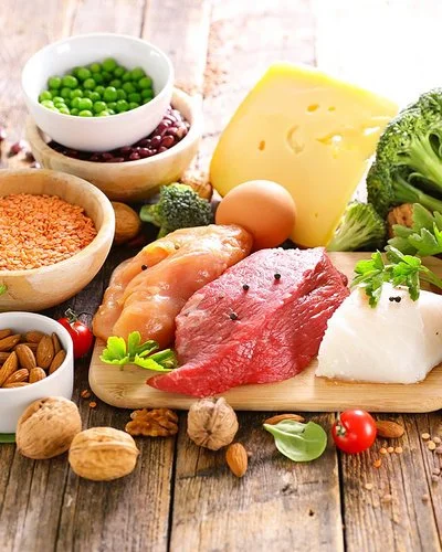 Ein reichlich gedeckter Tisch mit aminosäurehaltigen Lebensmitteln wie Fleisch, Nüssen und Eiern.