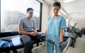 Junger Mann mit amputiertem Bein bei Training mit seiner Prothese gegen Phantomschmerz.