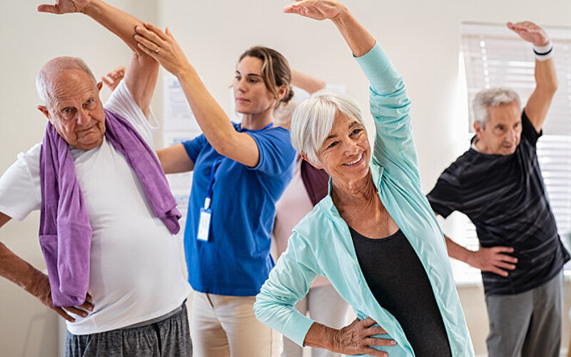 Senioren mit Herzinsuffizienz treiben Sport unter Anleitung einer Physiotherapeutin.