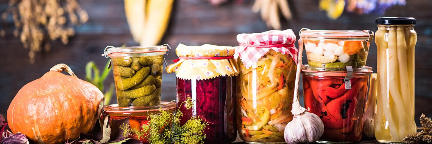 Fermentierte Lebensmittel in Gläsern stehen auf einem Tisch.