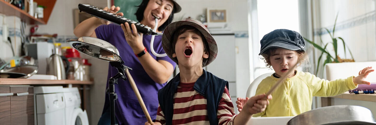 Mutter spielt mit Kindern fantasievoll in der Küche, sie fördert ihre Kinder ganz ohne Geld.