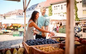 Eine Frau kauft auf dem Wochenmarkt ein.