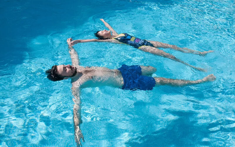 Zwei junge Erwachsene lernen Schwimmen mit Hilfe der Seesternübung.