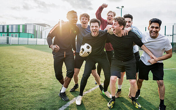 Eine Fußballmannschaft steht als Team zusammen und freut sich.