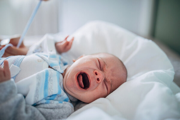 Ein Baby mit Schlafregression liegt auf dem Rücken und weint.