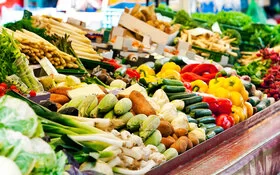 Frisches Gemüse und Obst wird auf einem Marktstand zum Verkauf angeboten. Darunter auch präbiotische Lebensmittel wie Spargel und Süßkartoffeln.