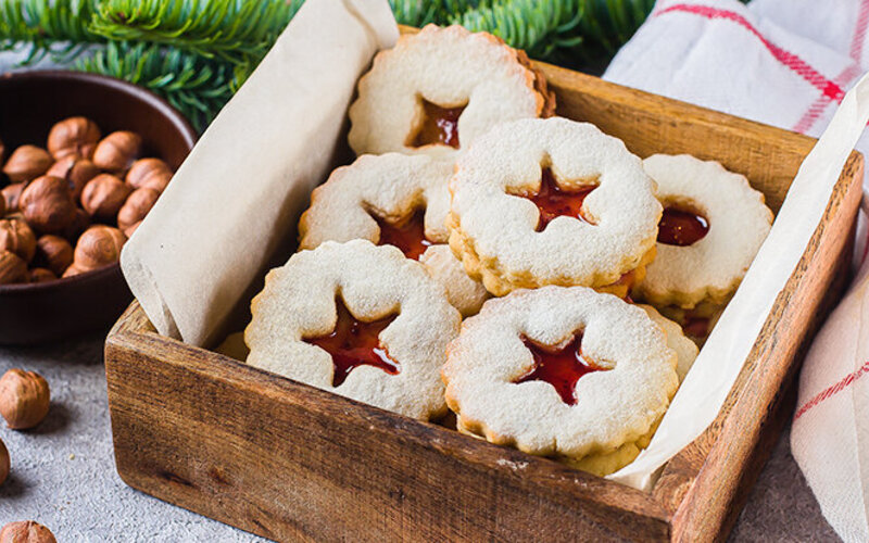 Linzer Sterne nach Low-Carb-Rezept in einer Holzschachtel serviert.
