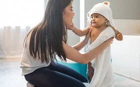 Eine Mutter trocknet ihr Baby ab