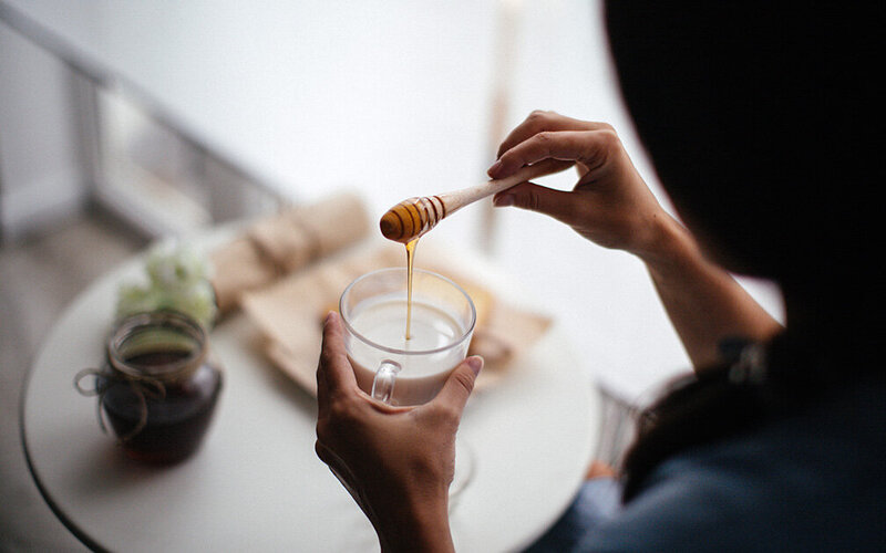 Frau setzt auf Honig in der Milch als schlafförderndes Lebensmittel.