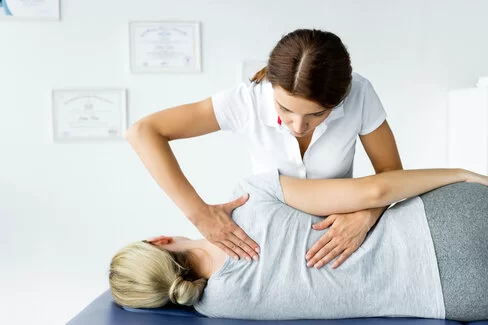 Eine Therapeutin behandelt eine Patientin. Osteopathie kann die wissenschaftsorientierte Medizin ergänzen.