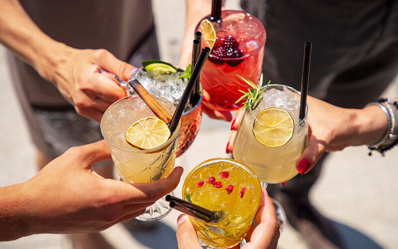 Mehrere Personen stoßen mit alkoholfreien Cocktails an.