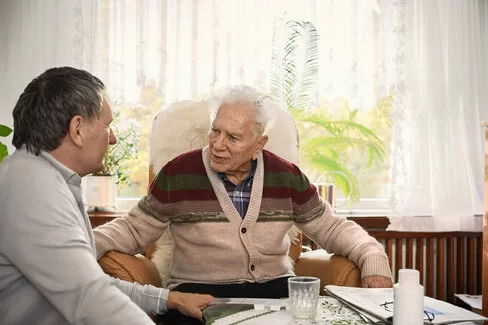 Ein Sohn spricht mit seinem älteren Vater. Mit einer Vorsorgevollmacht können Sie bestimmen, wer für Sie im Ernstfall entscheidet.