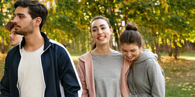 Zwei junge Frauen und zwei junge Männer gehen draußen spazieren. Sie wissen: Die AOK bietet ihnen als Krankenversicherung viele Vorteile.