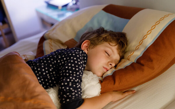 Ein Kind liegt im Bett und schläft.