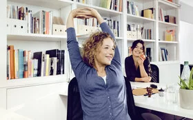 Eine Frau entspannt sich während ihrer Arbeitspause. Das AOK-Programm “Lebe Balance” hilft ihr, mehr Achtsamkeit in den Alltag zu integrieren.