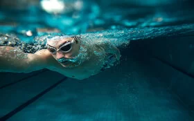 Eine Badekappe kann gegen Wasser im Ohr beim Schwimmen helfen.