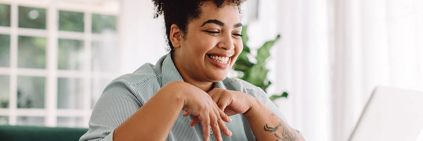 Eine junge Frau sitzt am Laptop und plant ihr Sabbatical.