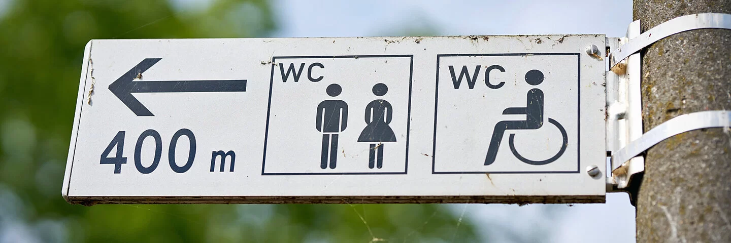 Ein Wegweiser zeigt den Weg zu einer öffentlichen Toilette, die 400 Meter entfernt ist.