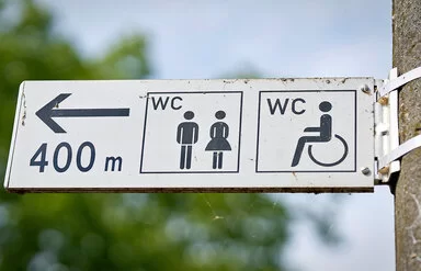 Ein Wegweiser zeigt den Weg zu einer öffentlichen Toilette, die 400 Meter entfernt ist.
